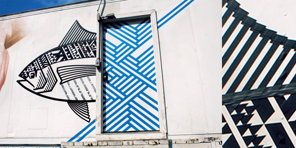 An outdoor tape art mural featuring a fish